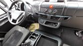 Front interior of a van: steering wheel, driver’s seat, dashboard with climate controls and red hazard button close to center.