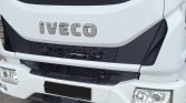 Front view of a white Iveco truck showing the grille, bumper, and dual headlights with chrome emblem on the hood area.