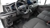 Interior of a modern van showing steering wheel, digital dashboard, and a large touchscreen infotainment display.