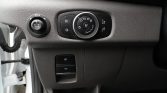 Dashboard interior: climate and light control panel with a central circular dial and surrounding buttons.