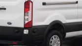 White Ford van shown from the rear-right side, highlighting the taillight, black bumper, and wheel with hubcap.