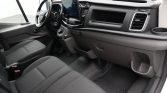 Interior of a van: driver’s seat, steering wheel, large infotainment screen, and dark dashboard.