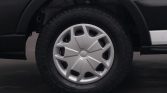 Front wheel of a vehicle with a silver hubcap and rugged tire treads visible beneath the fender