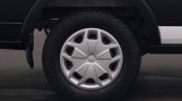 Close-up of a car wheel with a silver hubcap and black tire on a dark vehicle chassis