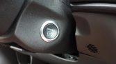 Car interior with a round push-button start/stop ignition labeled Power Start Stop surrounded by silver ring.