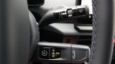 Close-up of car interior: steering wheel with wiper stalk and a gear selector panel showing EV, P, D, N, R buttons.