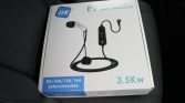 Boxed Ev charging cable with integral control unit, labeled 3.5 kW, on a car seat; shows selectable current options 8A/10A/13A/16A and NK brand logo.