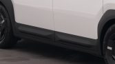Side view of a white SUV showing black lower body cladding and wheel arches visible near the tires.
