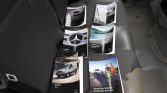 Mercedes-Benz brochures scattered on a car seat, including a van and service booklets near the door.”