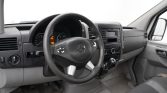 Front interior view of a van: steering wheel with Mercedes emblem, instrument cluster, and center console