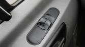 Close-up of dual power window switches on a car door armrest, used to raise/lower the front windows in a gray interior.