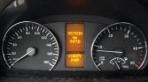 Vehicle instrument cluster with left speedometer up to 180 km/h, right tachometer, and center orange displays: odometer 57,030 km, trip 947.8 km; outside temp 18.5°C and time 21:07.