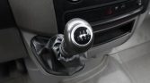 Manual gear shift lever with 1-6 and R pattern, leather boot, in a car's center console.