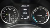 Car dashboard: left circular speedometer up to 180 km/h, central digital display with trip distance 548.1 km and odometer 40,548 km, and right circular gauge showing boost and power with a fuel/charge indicator nearby.