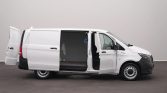 White cargo van with both side and rear doors open, exposing an empty cargo area near the back of the vehicle.
