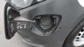 Front-left side of a car with the fuel filler cap exposed after the gas door is opened.