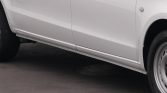White van seen from the side, showing damage to the lower side skirt near the front wheel area.