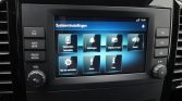 Autoinfotainmentscherm met Systeeminstellingen en tegels: Verbonden toestellen, Meldingen, Display en taal, Geluid, Tijd en eenheden, Radio, Over.
