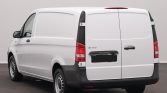 Rear view of a white Mercedes-Benz cargo van with double doors closed.