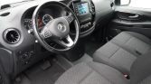Interior of a modern car: steering wheel with Mercedes logo, center touchscreen, climate controls, and front seats