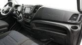 Vehicle interior: driver’s seat, steering wheel, gear shift, and central touchscreen on a dark dashboard.