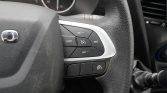 Close-up of a car steering wheel showing cruise control buttons (SET +, SET -, RES, CANCEL) on the right side with a silver trim.