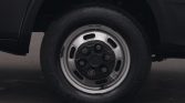 Close-up of a car wheel: black body with a silver steel rim and visible lug nuts on the tire-side hub