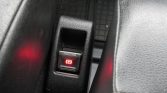 Electronic parking brake switch illuminated in red (P) indicating engaged status near the center console area of the car interior.