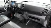 Front cabin of a Peugeot van showing steering wheel, instrument cluster, and center touchscreen infotainment system for the driver.