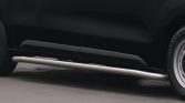 Black SUV side view showing a silver tubular side step running board beneath the doors and a visible wheel at the rear, low-to-ground appearance.